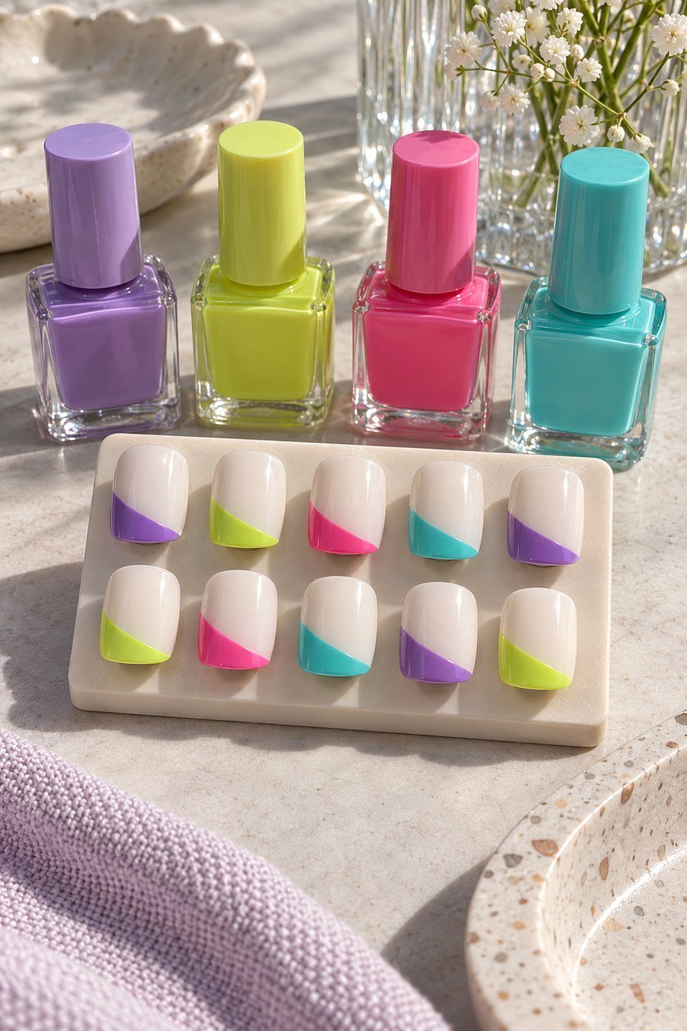 Unhas curtas quadradas com fundo branco e pontas diagonais de cores vibrantes